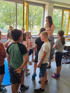 Kultur Spatzen in Aktion. Kinder stehen im Kreis und sprechen miteinander