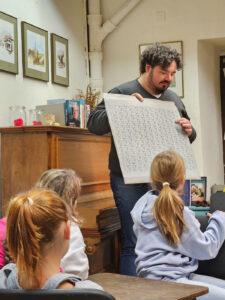 Mann zeigt den Spatzen eine Tafel