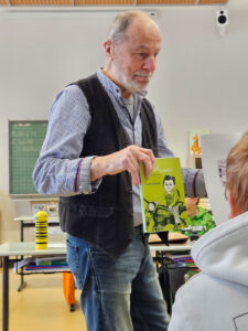 Ein Mann zeigt den Spatzen ein Buch