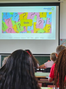 Eine Schulklasse verfolgt eine Präsentation über den kritischen Umgang mit Social Media und Online-Medien im Unterricht.