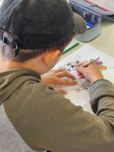 Ein Schüler gestaltet ein mittelalterliches Motiv und zeichnet eine historische Figur mit Bleistift und Filzstift aus.